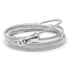May include: Silver zipper bracelet with a black crystal accent. The bracelet is made of multiple strands of zipper tape.