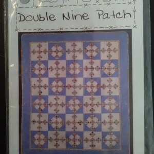 May include: A quilt pattern for a double nine patch quilt. The pattern features a blue and white checkered background with a white diamond pattern in each square. The text "Double Nine Patch" is written at the top of the pattern.