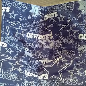 May include: A blue and white fabric bowl with a repeating pattern of stars and the word "Cowboys".