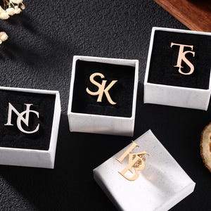 Op de afbeelding: Een witte keramische mok met een zwarte handgreep en de tekst "But First, Coffee" in een vetgedrukte, zwarte letter. De mok staat tegen een neutrale achtergrond, wat het eenvoudige ontwerp benadrukt.