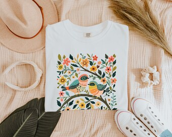 気まぐれな鳥と花のTシャツ、自然にインスパイアされたグラフィックTシャツ、カラフルな植物アートプリント、かわいい鳥のデザイン、花柄シャツ