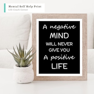 May include: A framed print with the text "A negative MIND WILL NEVER GIVE YOU A positive LIFE" on a black background. The frame is light brown. A small potted succulent is to the left of the frame. The text "Mental Self Help Print" and "Life Coach Corner" is at the top.