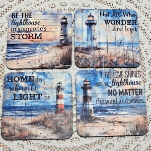 May include: Set of four square coasters with a lighthouse and beach scene. Each coaster features a different inspirational quote about light and hope. The quotes are: "Be the lighthouse in someone's storm", "Not all who wonder are lost", "Home is where the light is", and "True love shines as a lighthouse no matter the wind and waves".