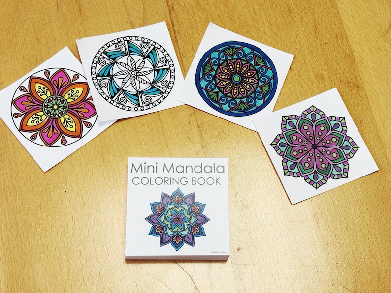 May include: A collection of colorful mandala designs on white squares and a mini coloring book. The designs feature intricate patterns in various colors, including pink, orange, blue, and green. The book cover displays a mandala design with the text "Mini Mandala Coloring Book".