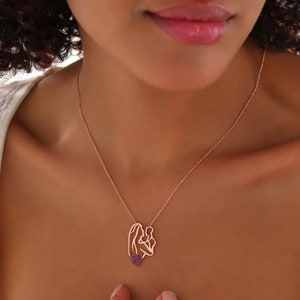 This necklace portrays a mother holding her baby under a red heart. Symbolizing love and maternal connection, it's a meaningful accessory suitable for any occasion