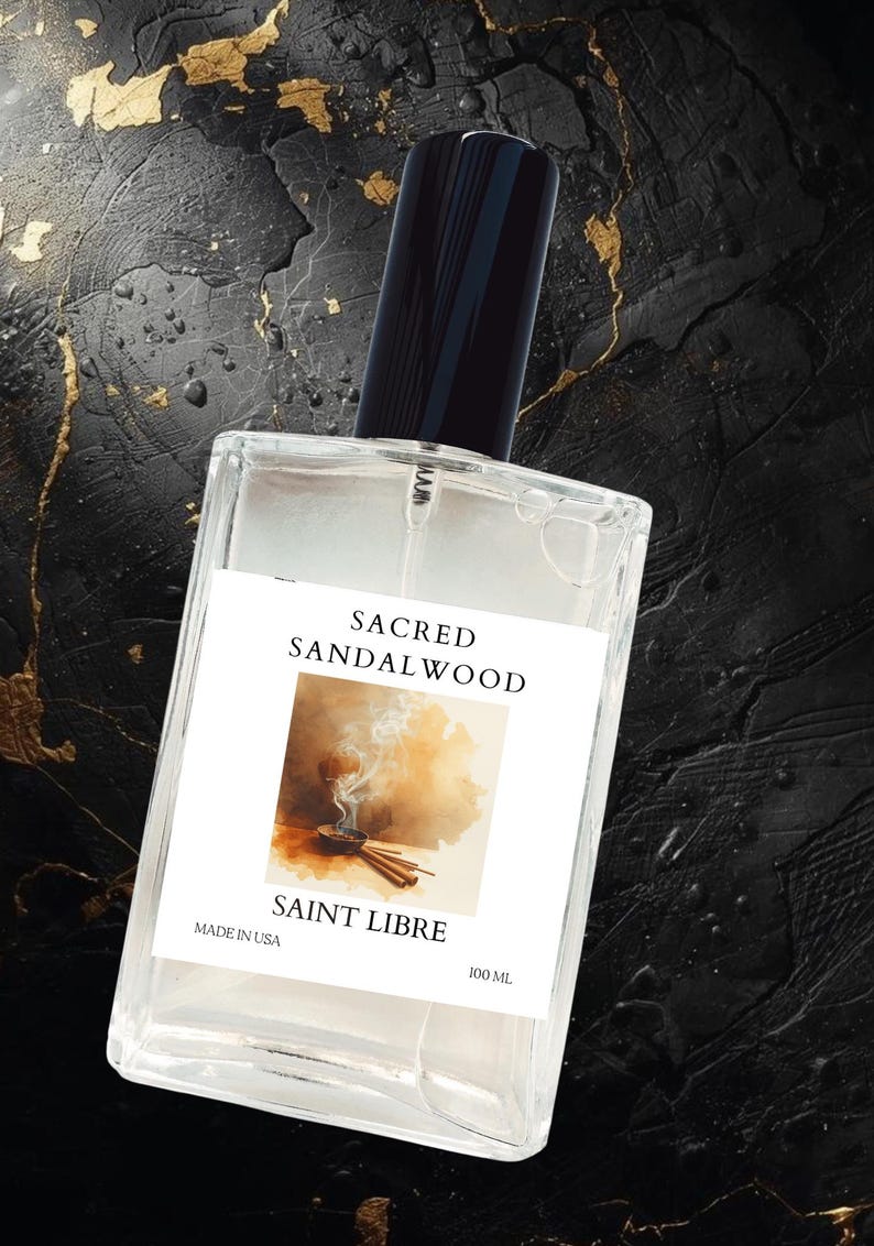 May include: A clear rectangular perfume bottle with a black cap. The label reads "SACRED SANDALWOOD" and "SAINT LIBRE" with an image of incense. The bottle contains 100 mL of perfume and is labeled "MADE IN USA".