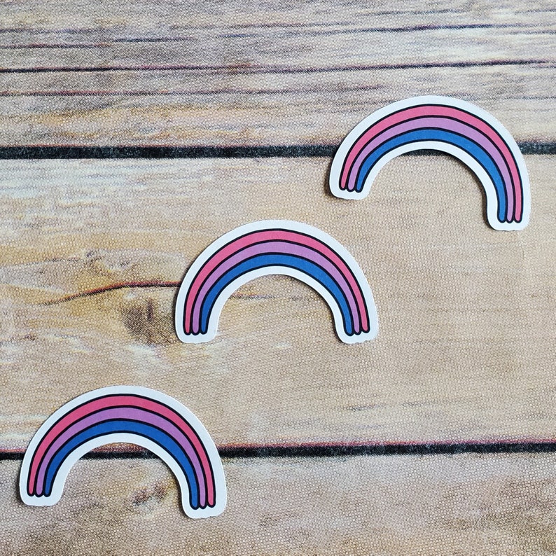 A cute sticker of a drawing of a rainbow with the colors of the bi pride flag. art by AnneArchy
