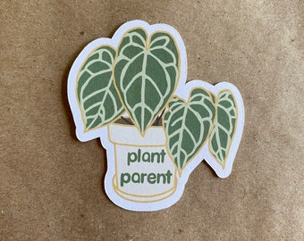 May include: A white sticker with a green plant in a white pot. The text "plant parent" is written on the pot.