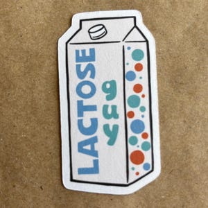 May include: A white carton with a blue and red design. The carton says "LACTOSE" and "Free" in a blue font. The carton has a red and blue polka dot pattern on the right side.