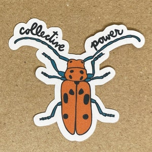 May include: A sticker featuring an orange beetle illustration with black spots and blue antennae and legs. The words "collective power" are written above the beetle in black script.