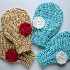 May include: Two pairs of knitted mittens, one pair is beige with red felt circles and the other pair is blue with white felt circles.