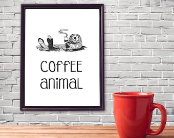May include: A black and white illustration of an otter holding a cup of coffee. The text "coffee animal" is printed below the illustration. A red coffee mug is sitting on a wooden table in front of the illustration.