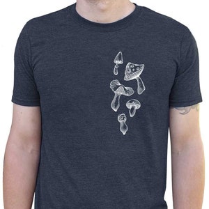 May include: A dark blue t-shirt with a white graphic of various mushrooms. The graphic is on the left side of the shirt.