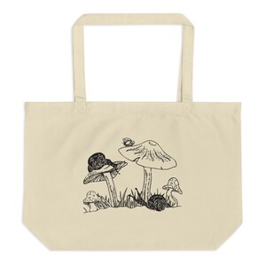 Op de afbeelding: Een witte tote bag met een zwart-witte illustratie van paddenstoelen en slakken. De paddenstoelen hebben een afgeronde bovenkant en een steel. De slakken kruipen op de paddenstoelen en de grond. Er zit een kleine vlinder op de bovenkant van een van de paddenstoelen.
