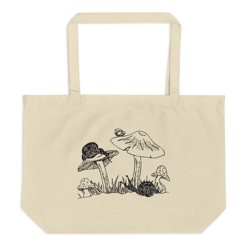 Op de afbeelding: Een witte tote bag met een zwart-witte illustratie van paddenstoelen en slakken. De paddenstoelen hebben een afgeronde bovenkant en een steel. De slakken kruipen op de paddenstoelen en de grond. Er zit een kleine vlinder op de bovenkant van een van de paddenstoelen.