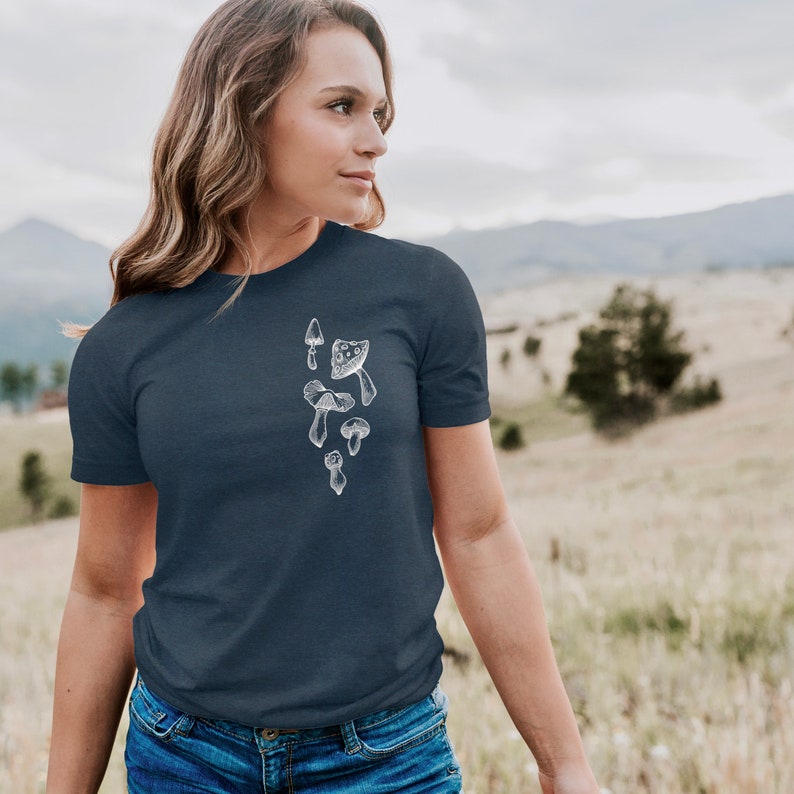 May include: A navy blue t-shirt with a white graphic of various mushrooms. The graphic is centered on the chest of the shirt.