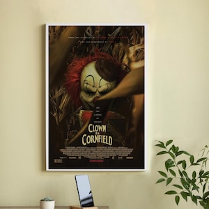 Peut inclure: Affiche de film d'horreur pour le film "Clown in a Cornfield". L'affiche présente un clown effrayant avec des cheveux roux et un visage blanc, tenant un couteau. Le clown se tient dans un champ de maïs, et le texte "Clown in a Cornfield" est écrit en gros caractères gras en bas de l'affiche.