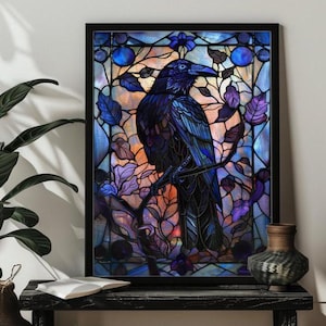 May include: A framed stained glass art piece featuring a dark blue raven perched on a branch. The artwork has a colorful background with blue, purple, and orange hues, and is framed in black. The raven is detailed with shades of blue and black.
