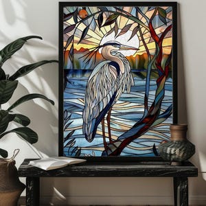May include: A stained glass style artwork depicting a blue heron standing in a tree by a lake at sunset. The heron is detailed with blue, grey, and white colours. The background features a sunset with orange, yellow, and blue hues.