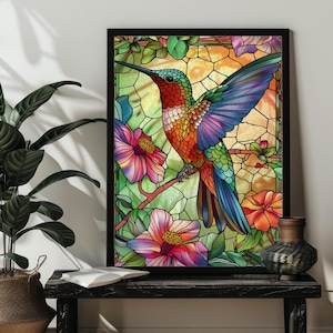 May include: A framed wall art print featuring a vibrant stained glass style illustration of a hummingbird in flight. The bird displays iridescent red, orange, green, and blue feathers, surrounded by colorful pink and orange flowers and green leaves.