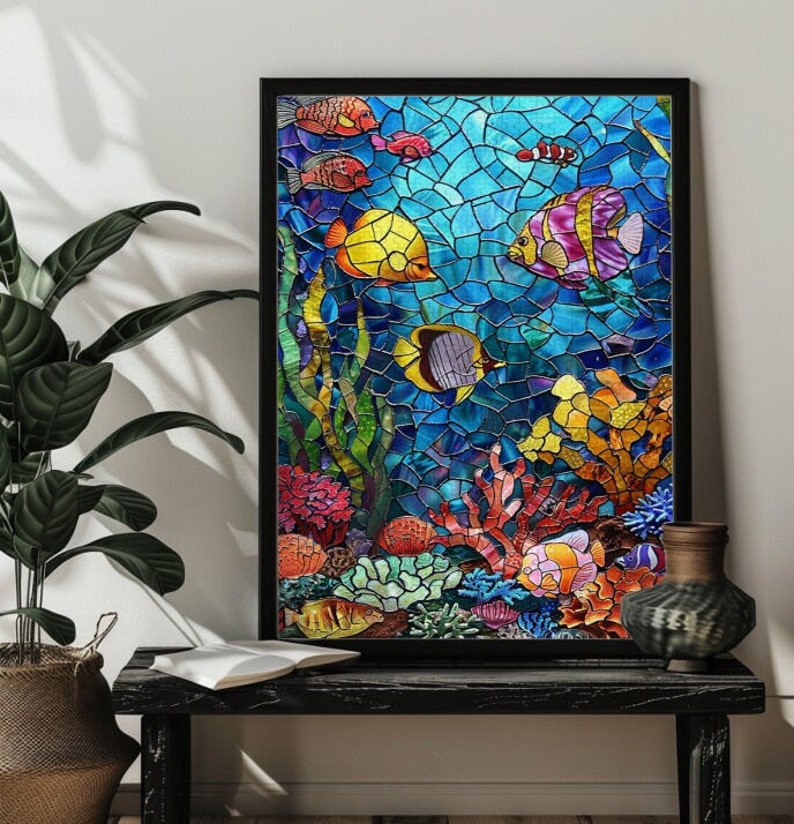 May include: A framed stained glass artwork depicting an underwater scene. The artwork features colorful fish, coral, and seaweed against a blue mosaic background. The fish are yellow, purple, orange, and red. The frame is black.