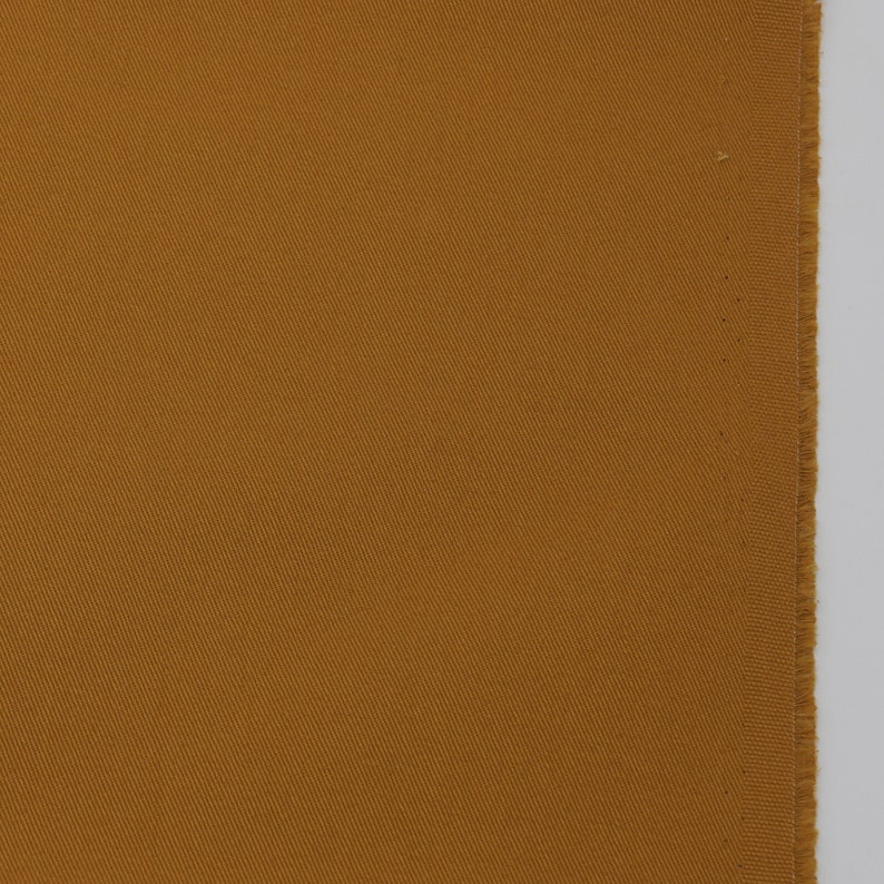 May include: A close-up of a piece of brown fabric with a subtle diagonal weave pattern.