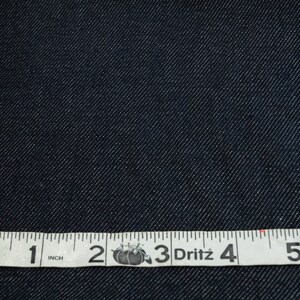 May include: Close-up of dark blue denim fabric with a white measuring tape that reads "1 inch 2 3 Dritz 4 5".