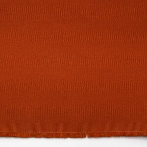 May include: A close-up of a piece of orange fabric with a textured weave. The fabric has a raw edge.
