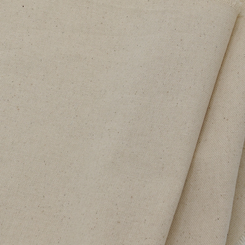 May include: Close-up of a natural beige canvas fabric with a subtle woven texture.