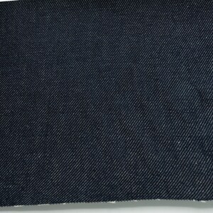 May include: Close-up of a dark blue denim fabric with a diagonal weave pattern.