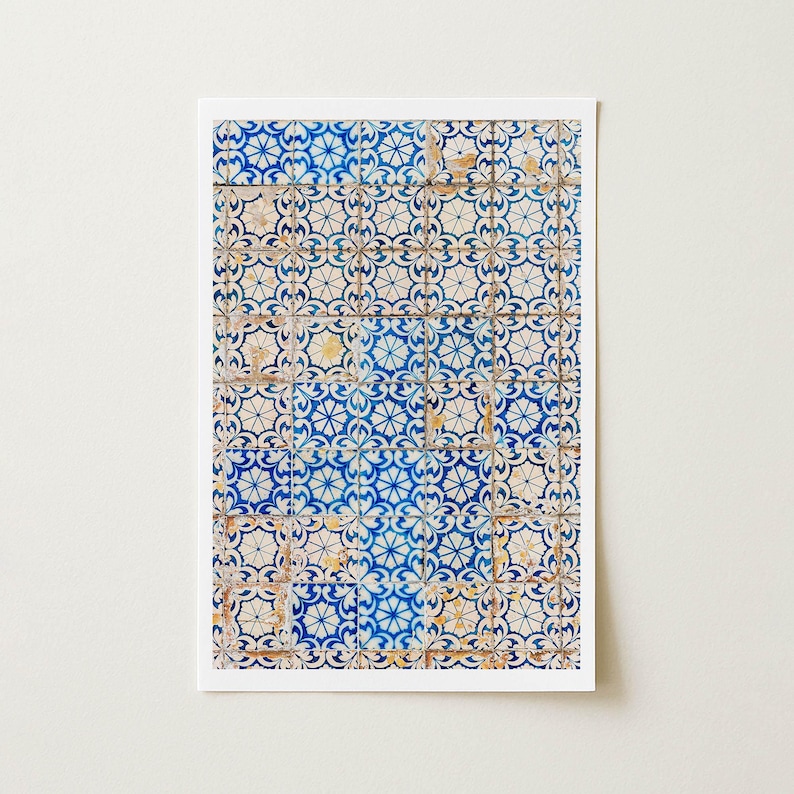 May include: A rectangular print featuring a close-up of traditional Portuguese tiles. The tiles display a repeating floral pattern in shades of blue and white, with hints of yellow and brown. The design is framed by a white border.