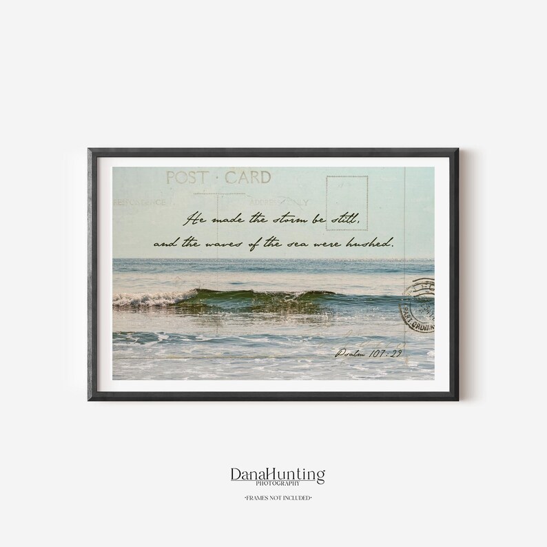 Horizontal photo of a calm glassy ocean wave.  Psalm 107:29 is imposed above the water in a handwriting script. Faint details of a vintage postcard create a collage effect.  Colors are pastel blue-green.