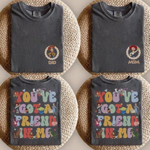 Peut inclure: Quatre t-shirts gris anthracite. Deux t-shirts pr&eacute;sentent un petit motif circulaire repr&eacute;sentant un cow-boy ou une cow-girl avec le texte DAD ou MOM. Deux t-shirts pr&eacute;sentent un grand motif color&eacute; avec le texte YOU'VE GOT A FRIEND IN ME.