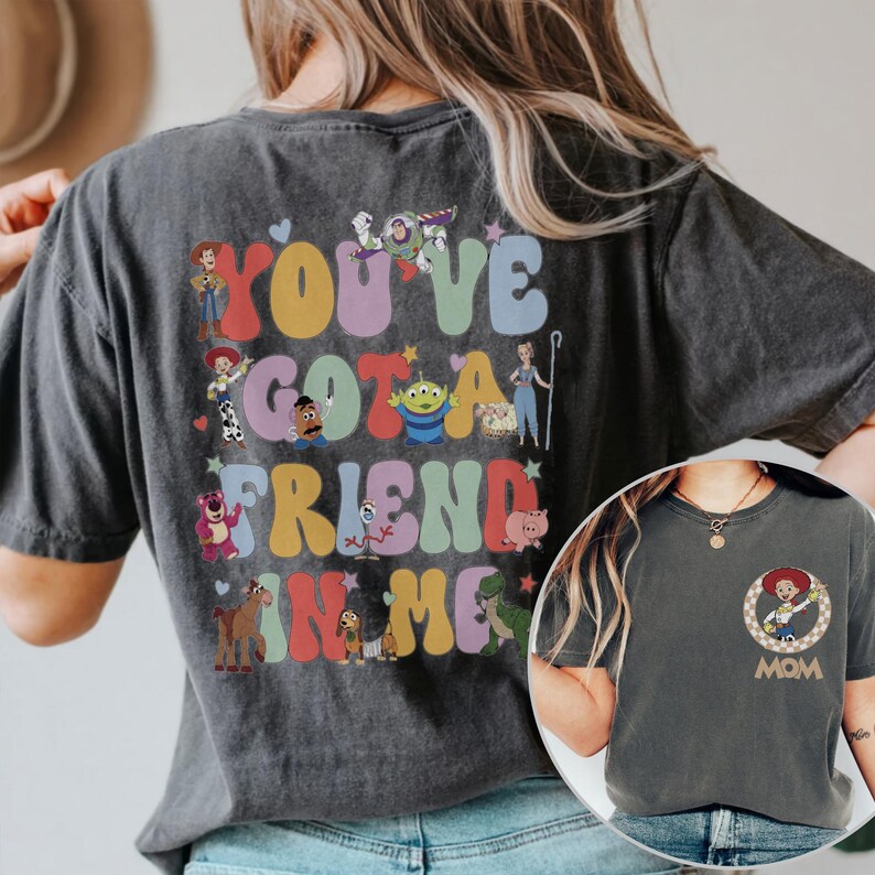 Peut inclure: Un t-shirt gris anthracite avec un grand motif au dos compos&eacute; de lettres color&eacute;es et arrondies formant "YOU'VE GOT A FRIEND IN ME", entour&eacute; d'illustrations de personnages de Toy Story. L'avant pr&eacute;sente un petit motif circulaire de Jessie.