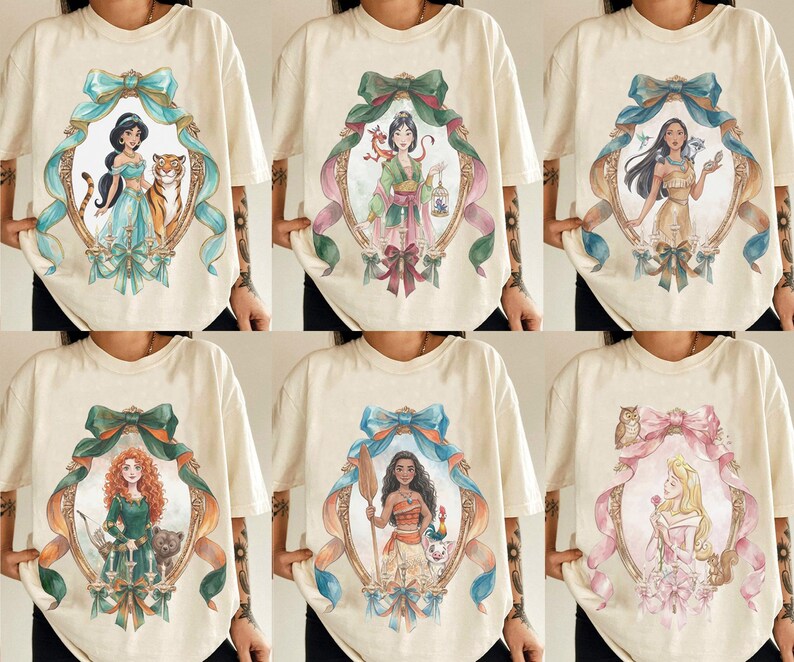 May include: Cream-colored t-shirts featuring watercolor portraits of Disney princesses within ornate frames. Each shirt showcases a different princess, surrounded by decorative bows and ribbons, creating a whimsical and artistic design.