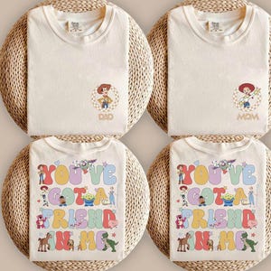 Peut inclure: Quatre t-shirts couleur cr&egrave;me avec des personnages de Toy Story. Deux t-shirts pr&eacute;sentent un petit motif circulaire de Woody ou Jessie avec le texte DAD ou MOM. Deux t-shirts arborent un grand motif color&eacute; avec le texte YOU'VE GOT A FRIEND IN ME.