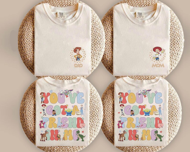 Peut inclure: Quatre t-shirts couleur cr&egrave;me avec des personnages de Toy Story. Deux t-shirts pr&eacute;sentent un petit motif circulaire de Woody ou Jessie avec le texte DAD ou MOM. Deux t-shirts arborent un grand motif color&eacute; avec le texte YOU'VE GOT A FRIEND IN ME.