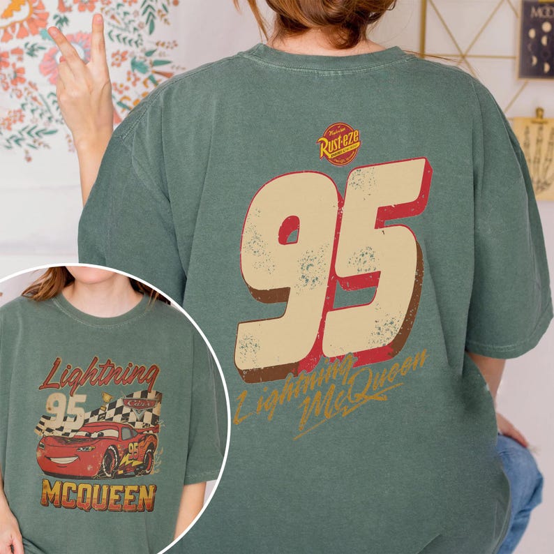 May include: Green t-shirt featuring the number 95 in a distressed style, with "Lightning McQueen" text. The shirt also has a graphic of a red race car and the text "Lightning 95 McQueen".