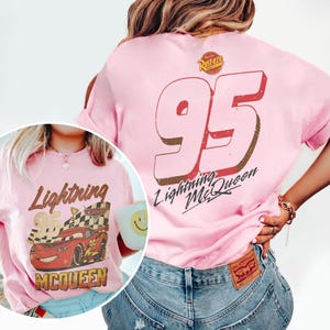 May include: Pink Lightning McQueen t-shirt with a graphic of the character and the number 95. The front of the shirt features Lightning McQueen with the text "Lightning 95 McQueen". The back has a large "95" and "Lightning McQueen" text.