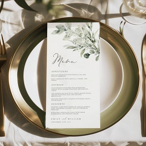 May include: A formal table setting with a gold-rimmed plate, gold cutlery, and a menu card. The menu card features floral illustrations and the word "Menu" in elegant script. The menu lists appetizers, entrees, and desserts.