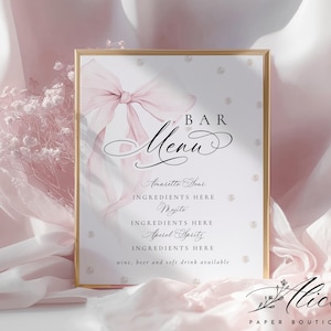 May include: A framed bar menu with a gold border, featuring a soft pink bow and the word "Menu" in elegant script. The menu lists cocktails like "Aperol Spritz" and "Mojito". The bottom right corner has the text "Alice Paper Boutique".