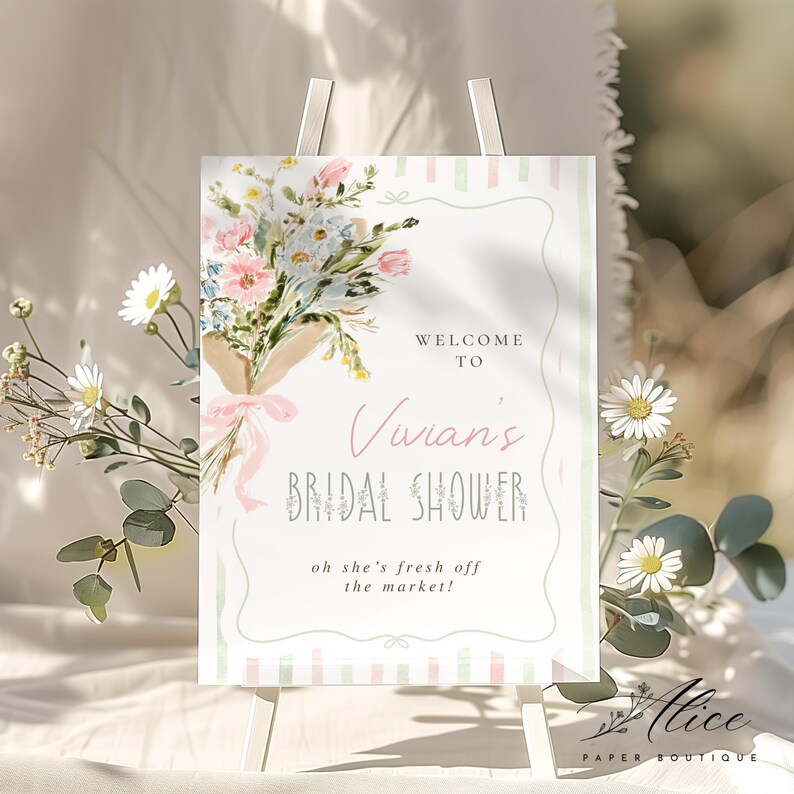 May include: A welcome sign for Vivian's bridal shower, featuring a floral bouquet and the text "Welcome to Vivian's Bridal Shower". The sign has a soft, pastel color scheme with a decorative border and the phrase "oh she's fresh off the market!"