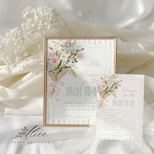 May include: A framed sign and recipe card set with floral bouquets and the text "Recipes for the BRIDE-TO-BE." The sign has a gold frame and features a watercolor design with pink and blue flowers.
