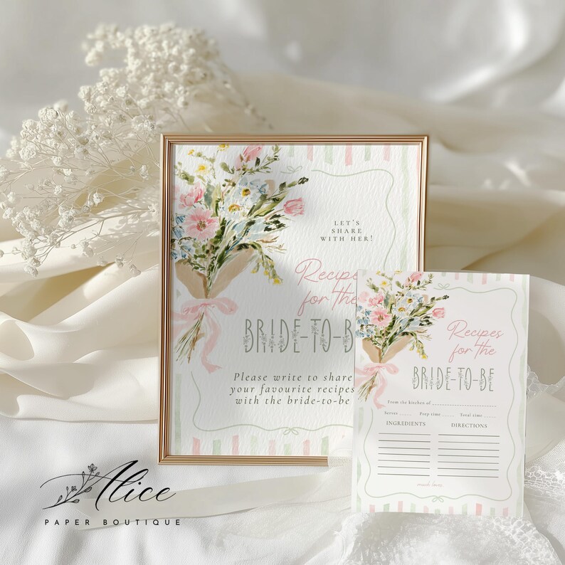 May include: A framed sign and recipe card set with floral bouquets and the text "Recipes for the BRIDE-TO-BE." The sign has a gold frame and features a watercolor design with pink and blue flowers.
