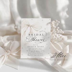 K&ouml;nnte beinhalten: Eine Einladung zur Brautparty mit einem Aquarell-Bogen und Perlenakzenten. Die Einladung enth&auml;lt den Text "Bridal Shower" und Details f&uuml;r Alicias Kate's Party, einschlie&szlig;lich Datum, Uhrzeit und Ort. Die Einladung stammt von Alice Paper Boutique.
