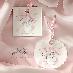 May include: Two white paper tags, one square and one circular, each featuring a soft pink watercolour bow illustration and the text Custom TAG with placeholder lines. Both tags are attached to pink ribbons and display the Alice PAPER BOUTIQUE logo.