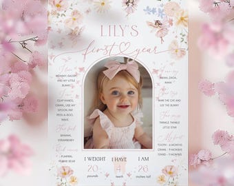 May include: A pink and white floral first birthday milestone sign with a photo of a baby girl. The sign includes the baby's name, Lily, and details about her first year, including her weight, height, and number of teeth. The sign is decorated with butterflies and flowers.
