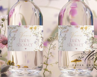 Könnte beinhalten: Zwei klare Wasserflaschen mit weißen Verschlüssen und Etiketten für eine Babyparty. Die Etiketten zeigen florale Designs in Gelb, Lila und Weiß mit dem Text "Vivian's baby shower". Die Flaschen sind mit einer klaren Flüssigkeit gefüllt und von Blumen umgeben.