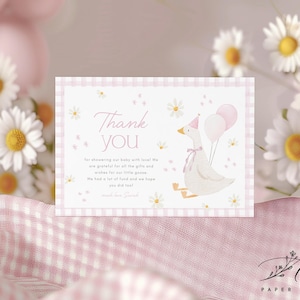 May include: A pink and white thank you card featuring a white goose wearing a pink party hat and holding pink balloons. The card has a gingham pattern and says "Thank you" in a pink script font. The text reads "for showering our baby with love! We are grateful for all the gifts and wishes for our little goose. We had a lot of fun and we hope you did too!"