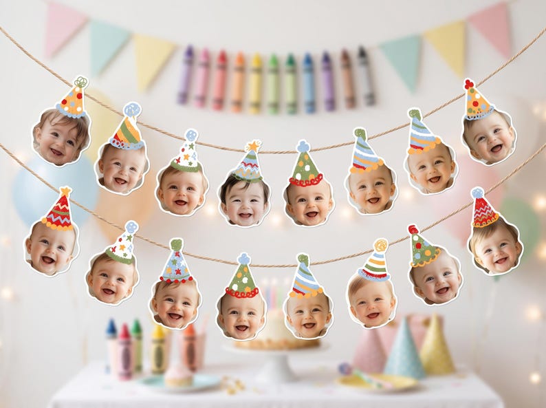 May include: A decorative party banner featuring a series of cutouts of smiling infants wearing colorful, patterned party hats. The cutouts are suspended from a thin, natural-colored twine string, arranged in two horizontal rows for display.